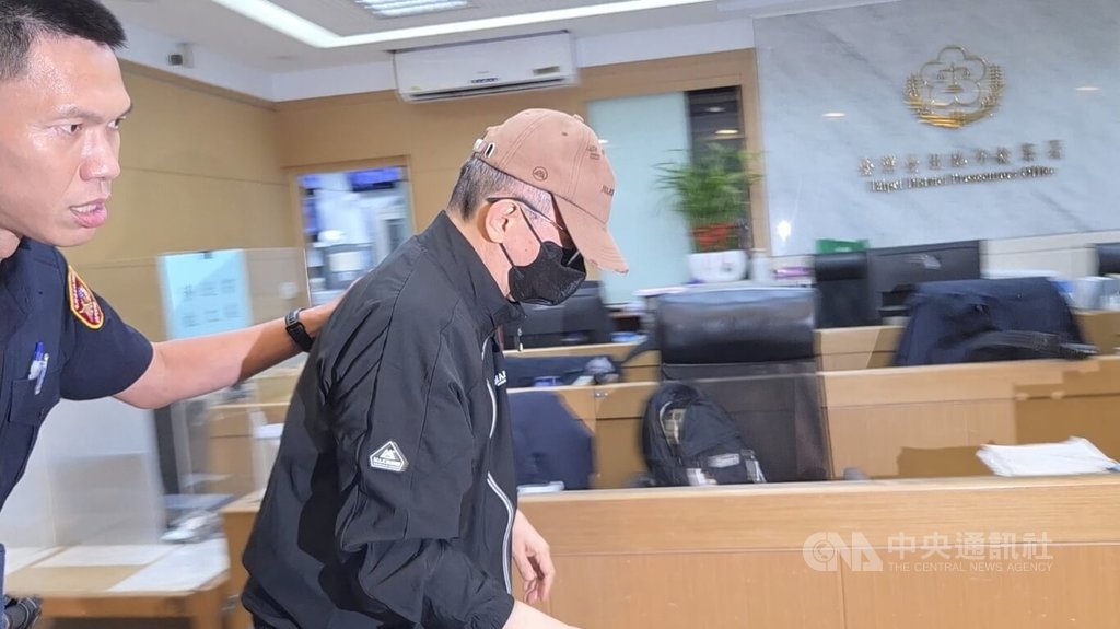 長榮集團創辦人張榮發三子張國政（中）遭控涉及內線交易，6日他戴著帽子、口罩至台北地檢署複訊，低頭不語。中央社記者謝君臨攝　115年7月6日