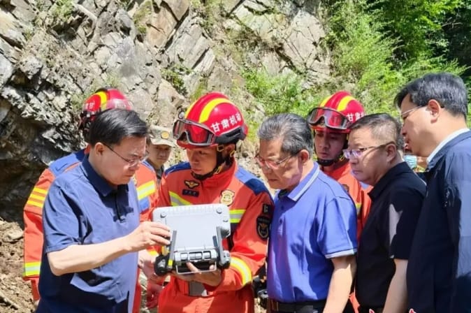 甘肅發生山崩，當地官員趕至現場關切，但衣著乾淨整齊，疑似擺拍。 圖 : 翻攝自極目新聞