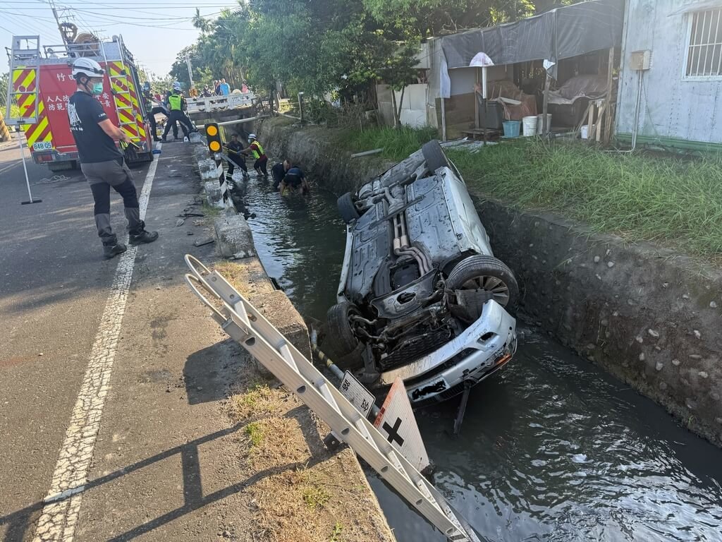 屏東縣竹田鄉8日上午發生車禍，1輛轎車與1部機車碰撞掉進大排水溝，汽車駕駛輕傷受困車內，由消防人員協助脫困。（屏東縣政府消防局提供）中央社記者黃郁菁傳真　115年7月8日