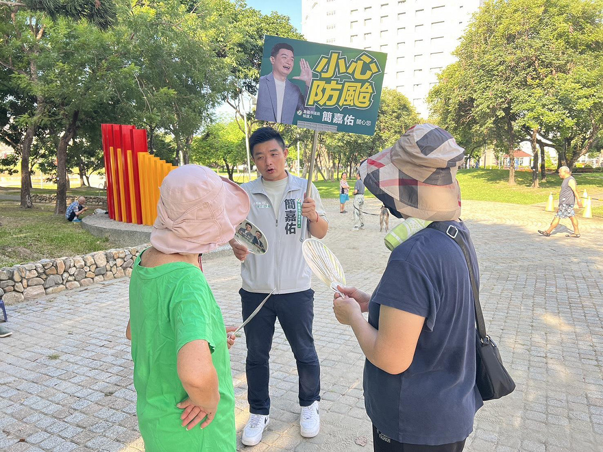 簡嘉佑（中）的手舉牌內容會跟進時事。  圖：簡嘉佑/提供