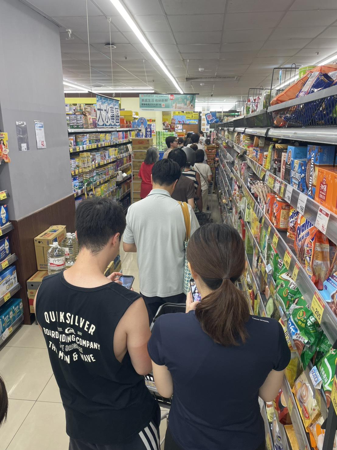 強颱巴威逼近，民眾湧入賣場搶購防颱物資，結帳時形成大排長龍的景象。 圖：張正霖攝