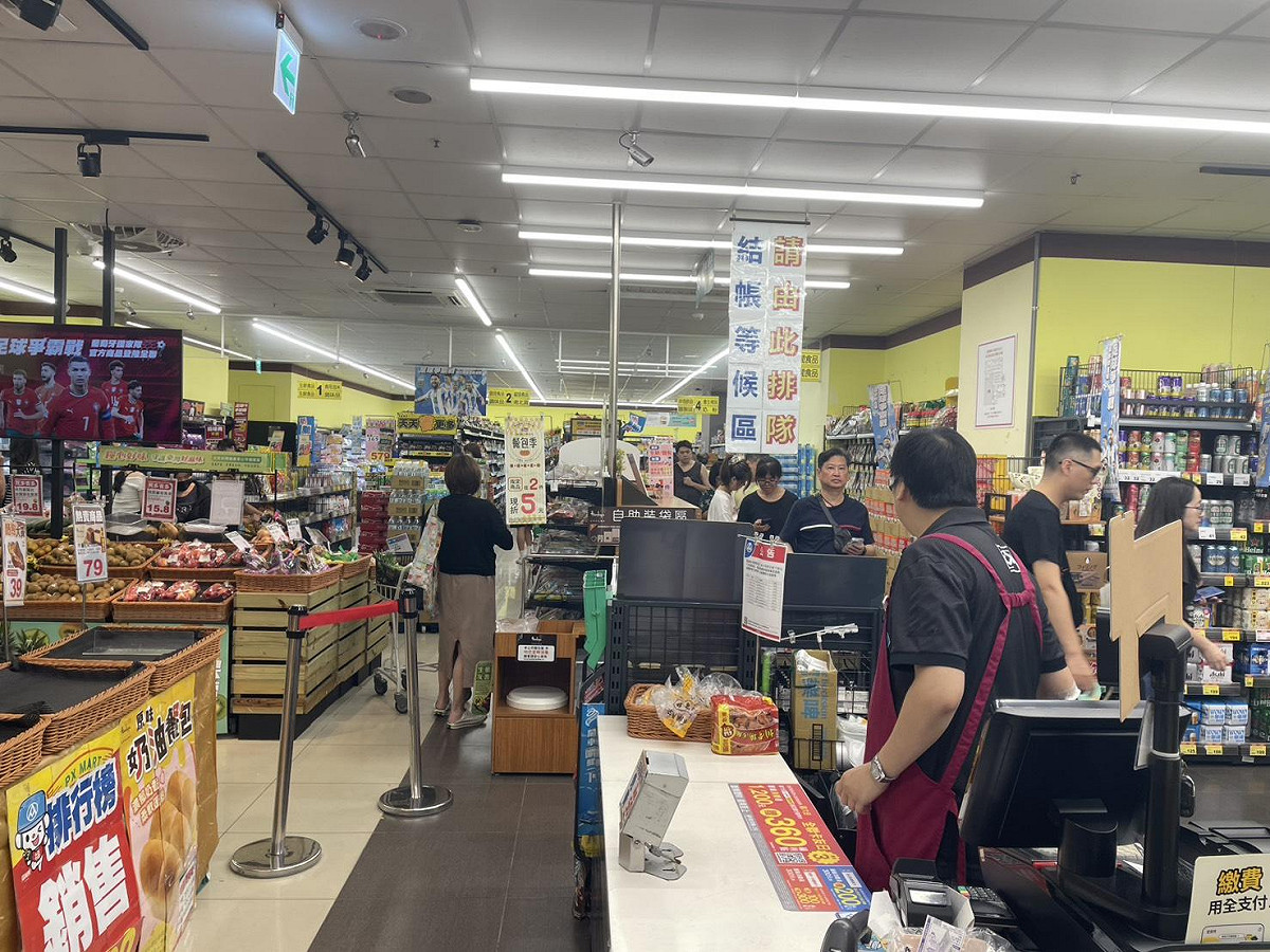 強颱巴威逼近，民眾湧入賣場搶購防颱物資，結帳時形成大排長龍的景象。 圖：張正霖攝