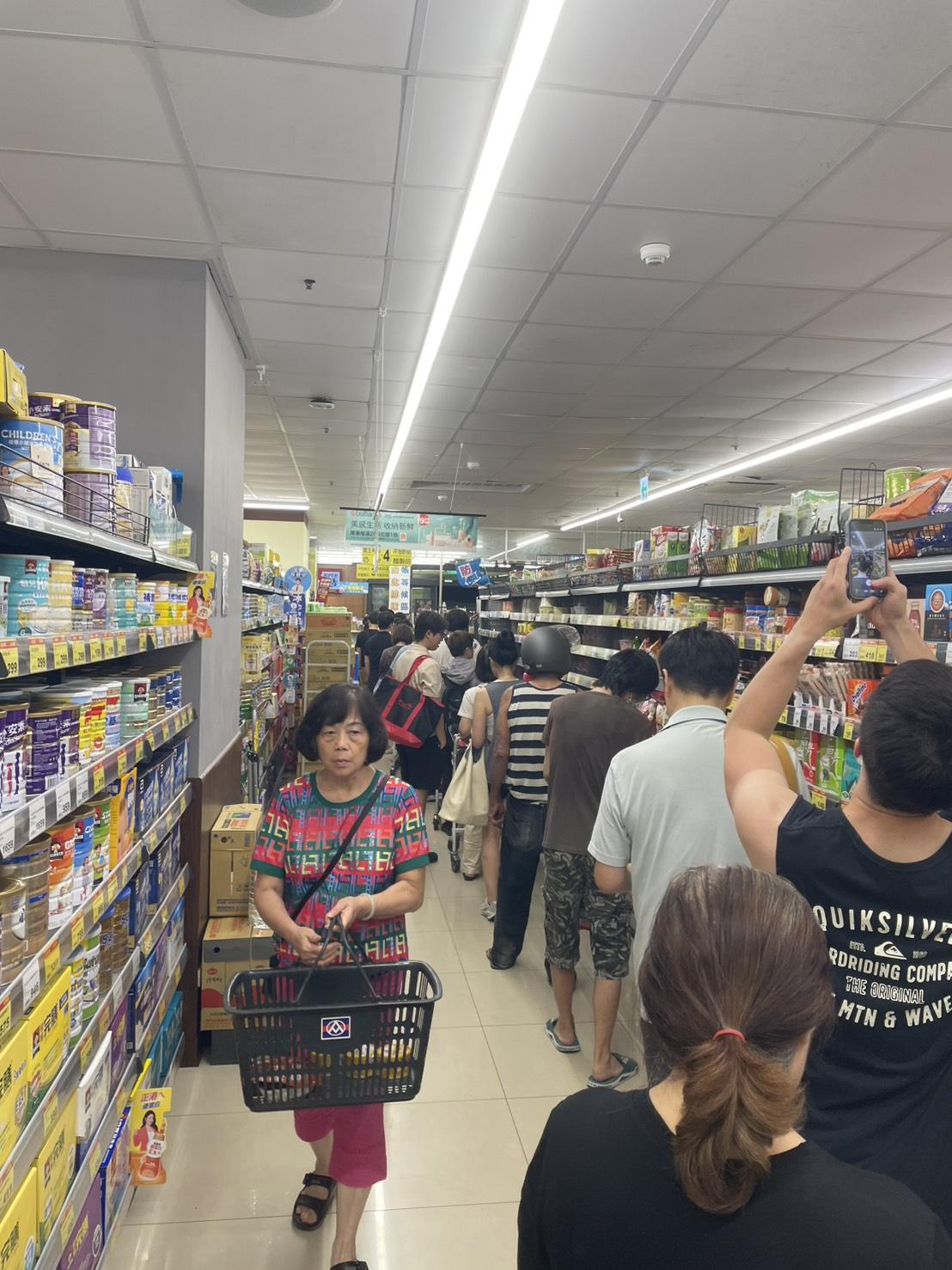 強颱巴威逼近，民眾湧入賣場搶購防颱物資，結帳時形成大排長龍的景象。 圖：張正霖攝