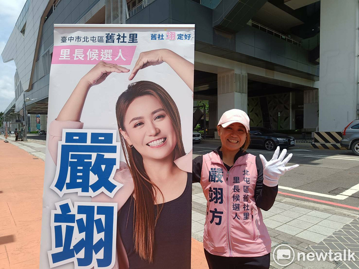 縱使烈日當頭、氣溫持續飆高，嚴翊方依然選擇在路口，獨自一人頂著高溫高舉大型宣傳看板，面帶微笑向路過的市民揮手問候。 圖：唐復年/攝
