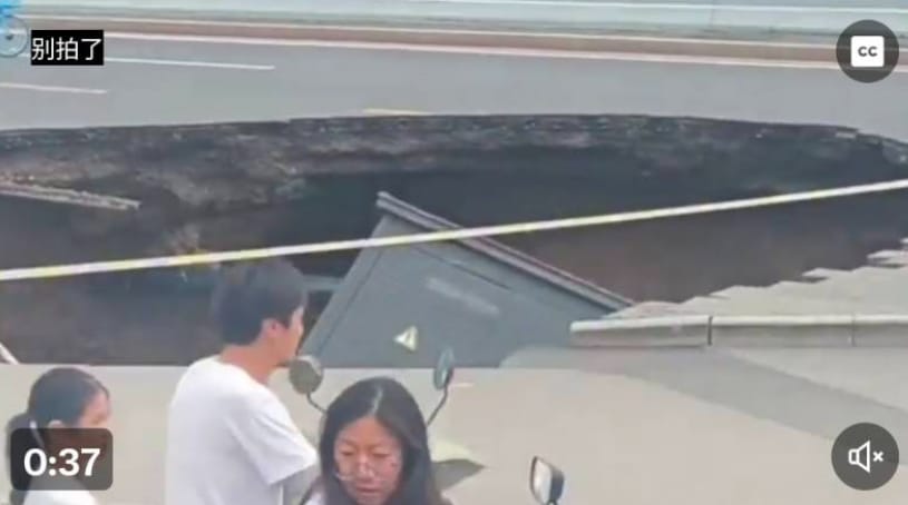 中國連續暴雨釀災情，北京路面驚見天坑，還有車輛陷落其中，當局派人管制，警告路過者別拍攝。 圖 : 翻攝自 X / 趙蘭健