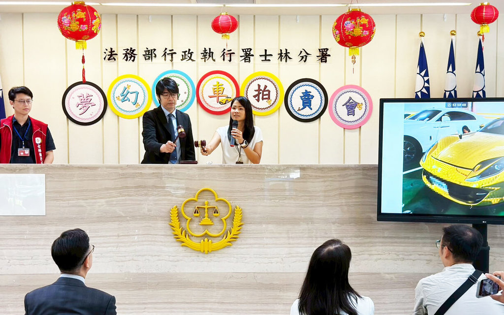法務部行政執行署士林分署14日舉辦「夢幻名車拍賣會」，其中2019年出廠、金色法拉利812 GTS以新台幣1698萬元拍定。圖左2為台北地檢署主任檢察官黃育仁，右為士林分署行政執行官陳靜慧。（士林分署提供）中央社記者謝君臨傳真　115年7月14日