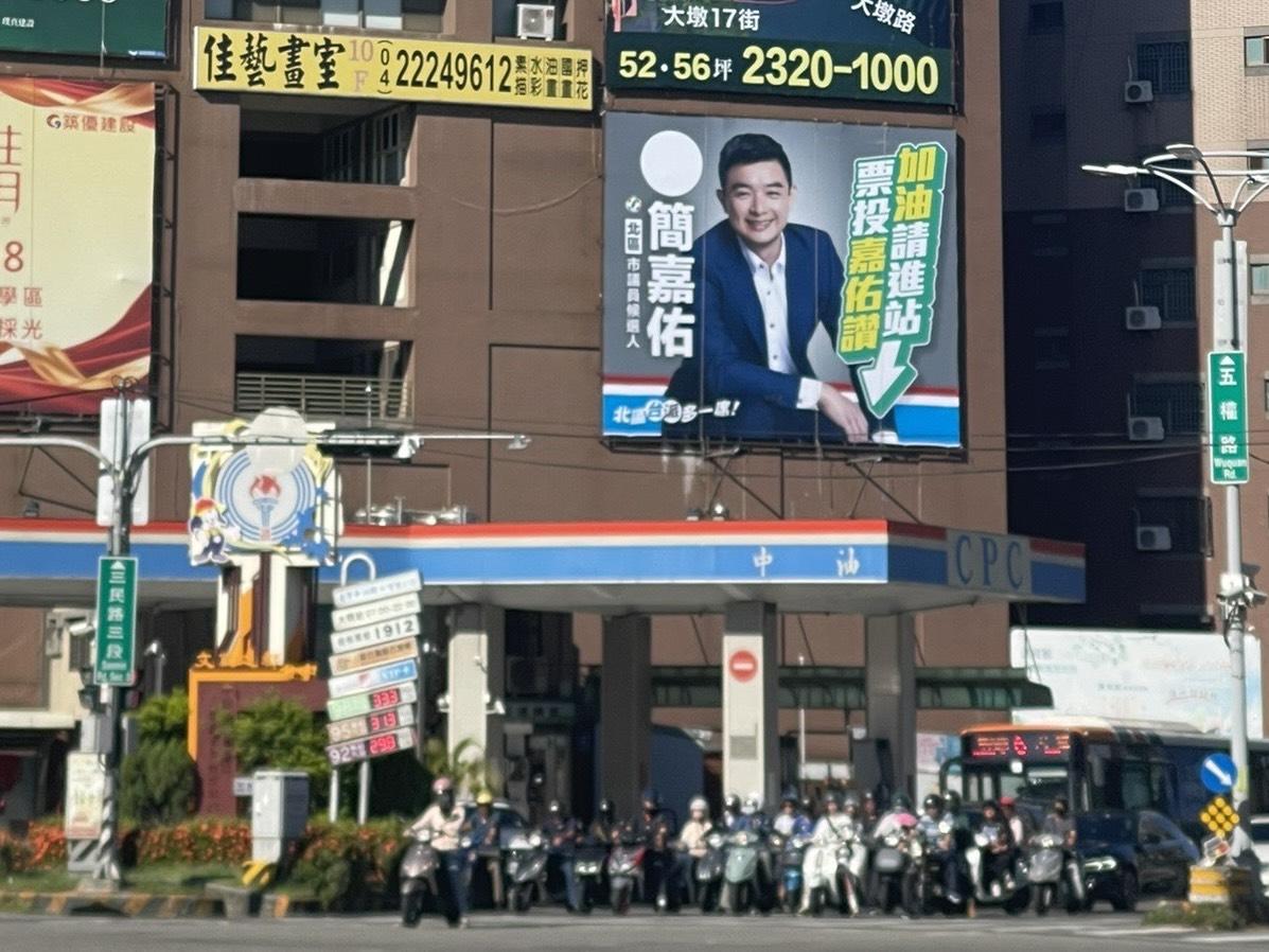 這面設在北區五岔路口加油站旁的看板，簡嘉佑將加油站的意象與自己的名字結合，大打「嘉佑讚」諧音梗。 圖：簡嘉佑/提供