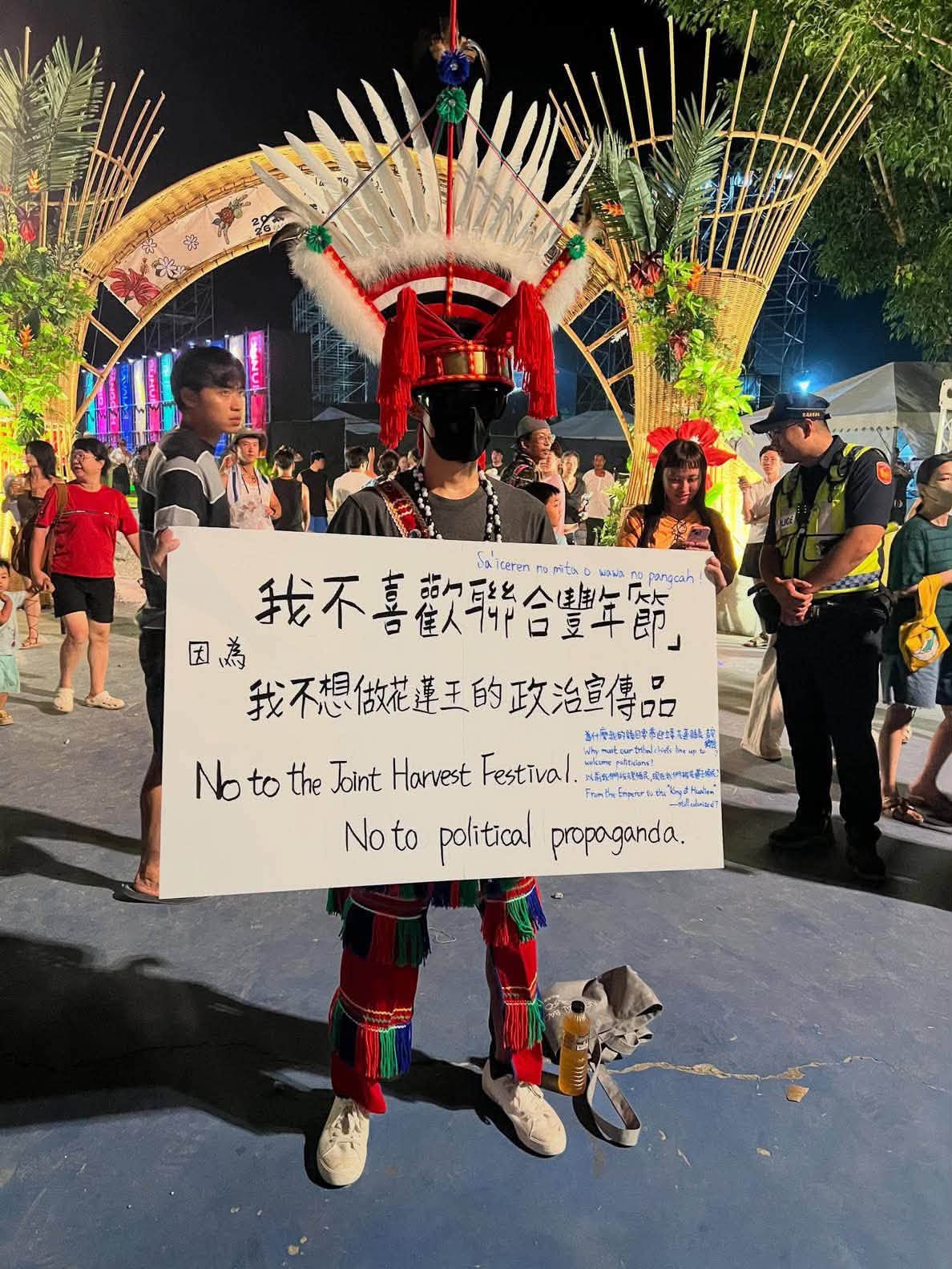 有一名蒙面、身掛原住民傳統佩刀的男子舉牌表達意見，警方基於維安考量上前盤查，並在男子拒絕配合後帶返前進指揮所查證身分。 圖：翻攝自臉書帳號 @戲謔蘿莉塔
