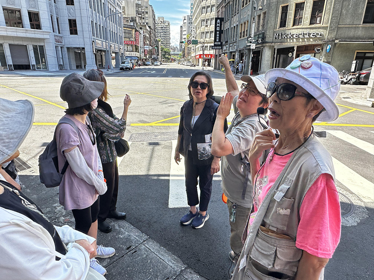 人權體驗營走讀二二八事件發生地，台北巿文獻導覧員鄭麗真（右）講述當年受難者陳文溪遭槍擊搶救不治的歷史現場。 圖：國家人權博物館提供