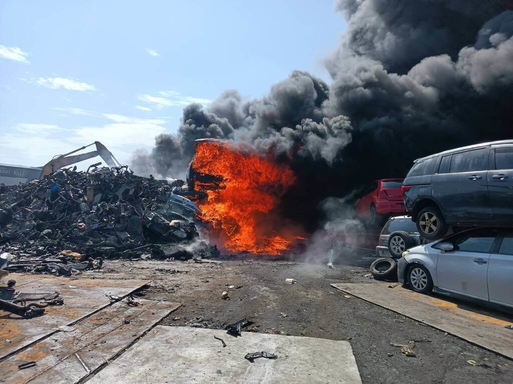 屏東市一處汽車回收場21日下午發生火警，多輛廢棄車輛在熊熊大火中燃燒，現場濃煙密布，警消獲報馳援搶救。（屏東縣消防局提供）中央社記者李卉婷傳真　115年7月21日