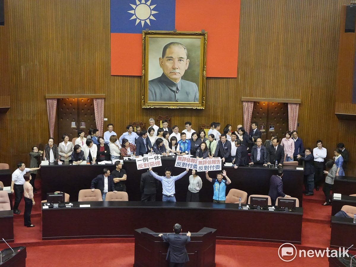 行政院日前頒布一例一休勞基法部分條文修正草案，民進黨團力拚在今（17）天立法院院會完成一讀付委審查，國民黨團佔據議場主席台抗議。 圖：趙婉淳／攝