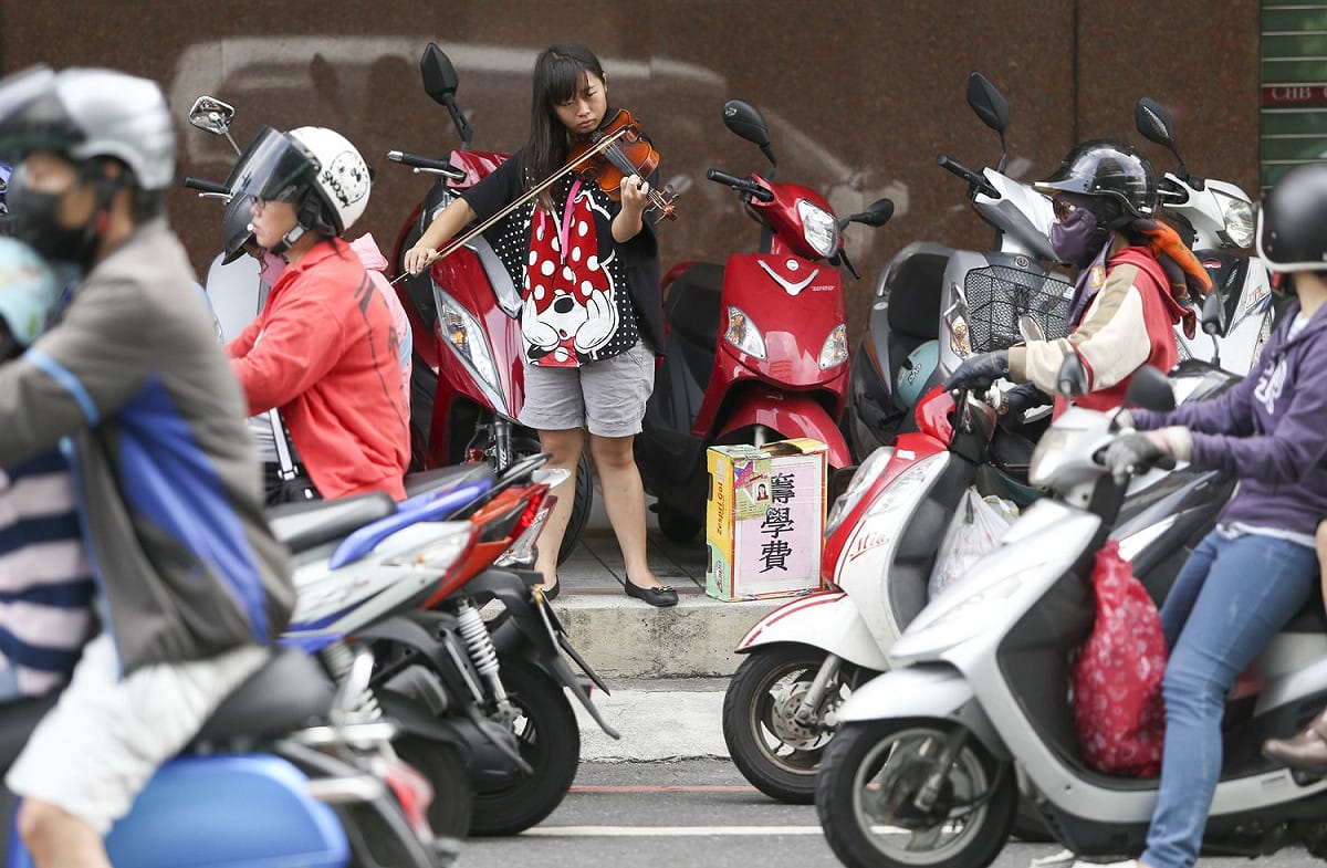 曾子恩最希望紅燈亮起或火車經過，機車騎士打賞的機率就提高。 圖：張大魯/攝(資料照片)