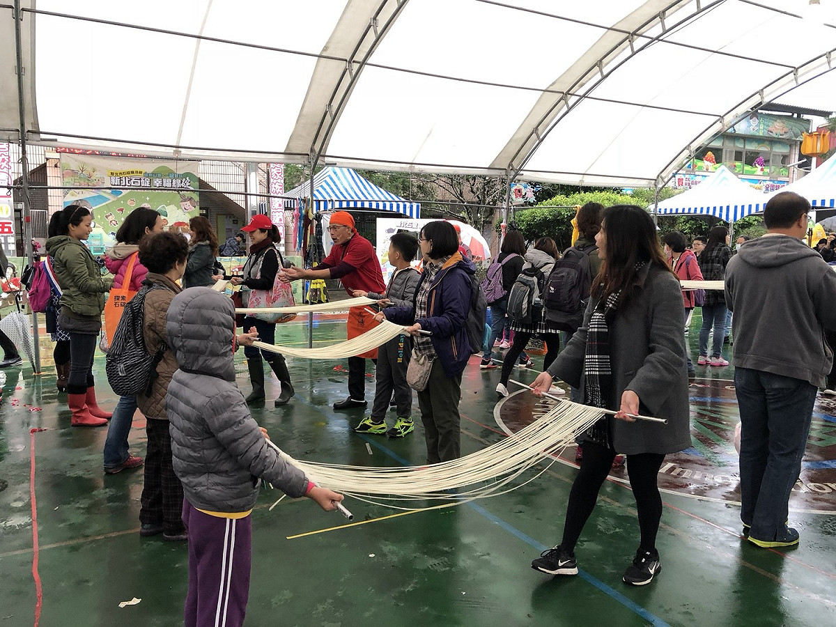今(25)天「2017新北石碇 幸福線碇」舉辦百人拉麵線活動。 圖：新北市經發局提供