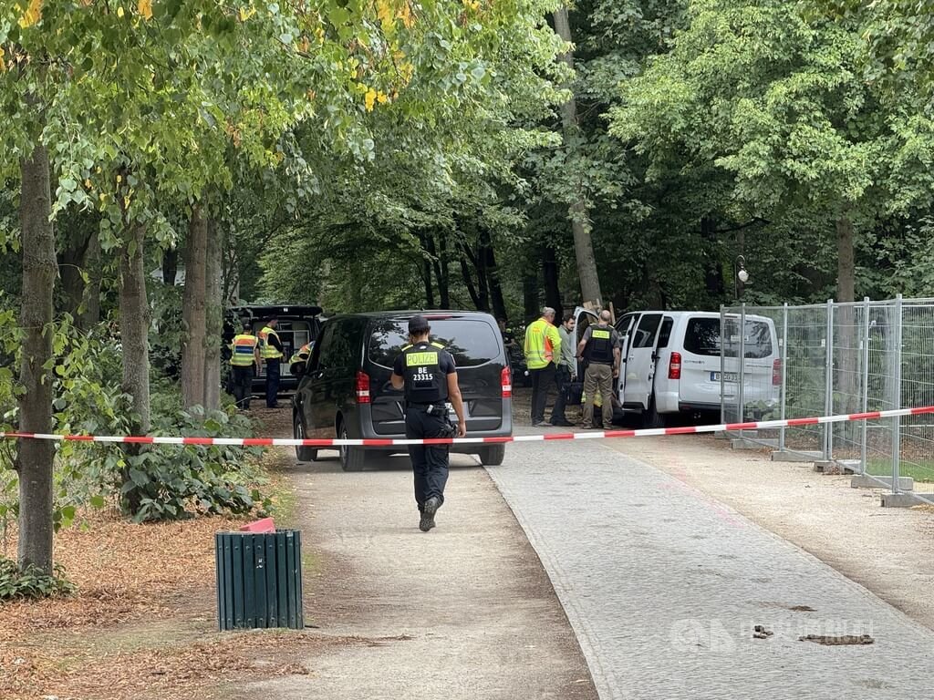 德國柏林同志遊行汽車衝撞案，嫌犯駕駛的白色箱型車衝入蒂爾加滕公園後撞上樹木停下，隨後棄車持刀逃逸。圖為警方26日在案發現場封鎖調查，白色箱型車仍停放於現場。中央社記者林尚縈柏林攝　115年7月27日 圖：中央社提供