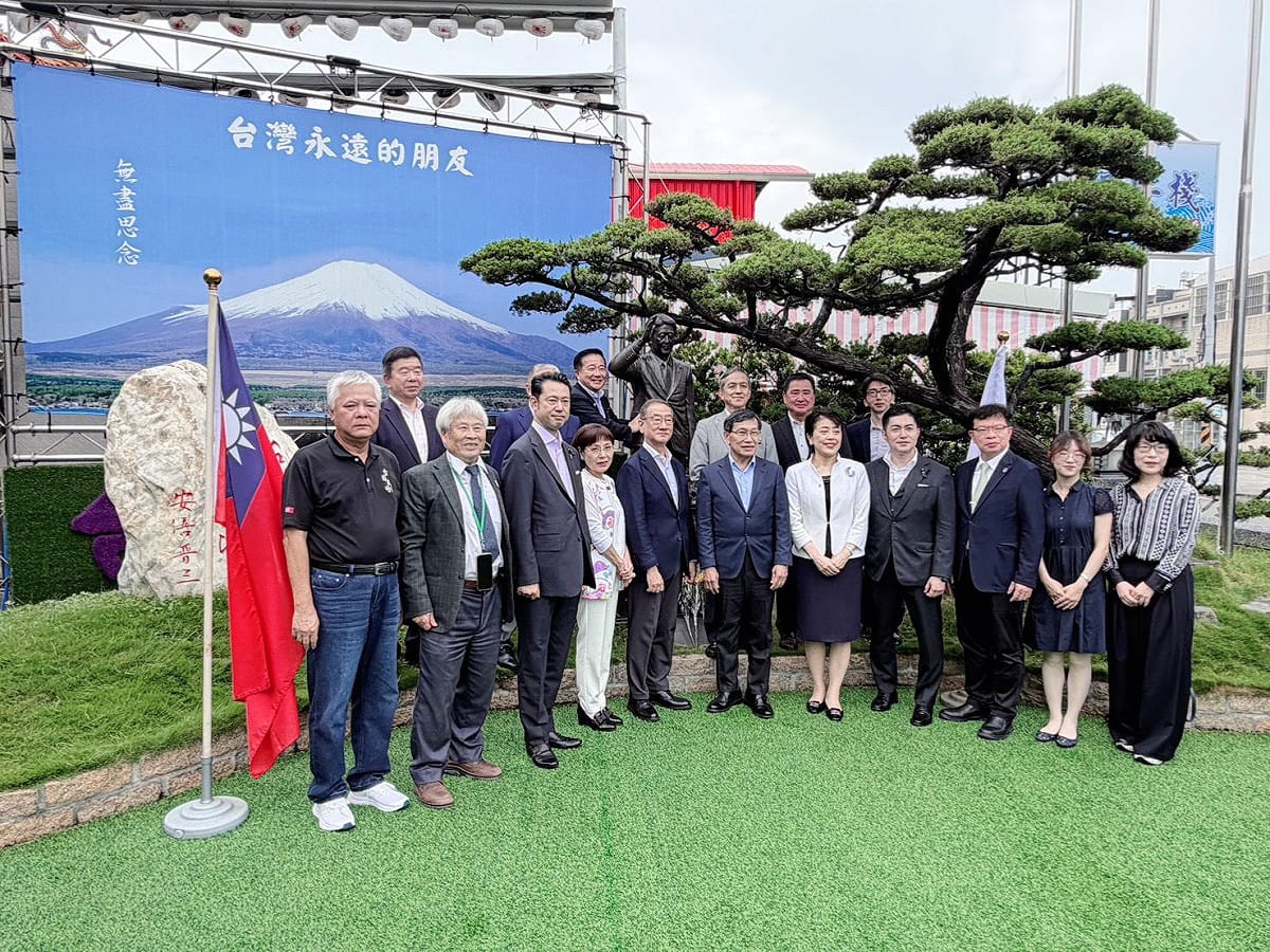 張吉雄(左一)與日本國會議員參訪團在安倍晉三銅像前合影。 圖：孫家銘翻攝