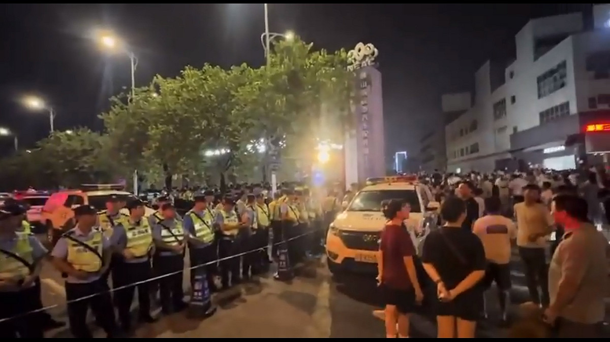 當地時間 13 日晚間，大批貴州人齊聚學校門口抗議，廣東佛山警方封鎖了周邊道路。 圖：擷取自 @whyyoutouzhele X 分享影片