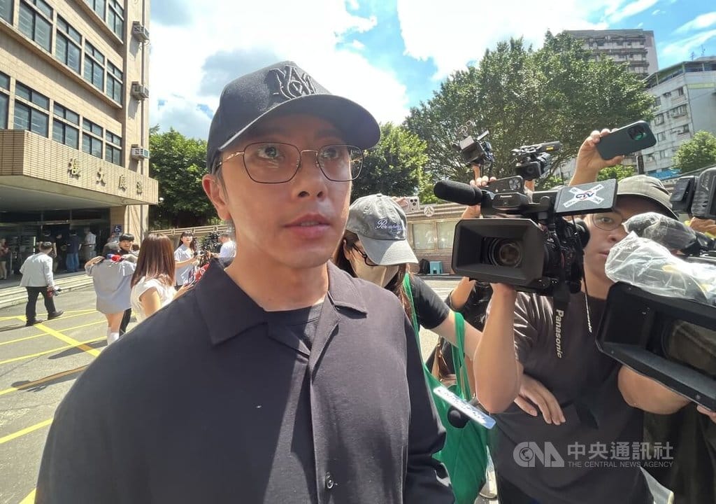 藝人閃兵案開庭審理，藝人坤達（前左）21日上午遭新北地方法院傳喚出庭，結束後面對媒體堵訪低調離開。中央社記者趙世勳攝　115年8月21日