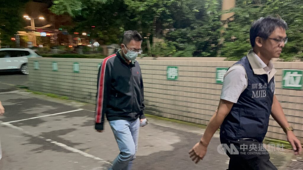 國民黨新北市議員王威元疑涉關說標案，新北地檢署發動搜索帶回5名被告，12日凌晨王威元（左）被移送至地檢署複訊，檢方訊後諭知200萬元交保，全案朝貪污治罪條例偵辦。（翻攝畫面）