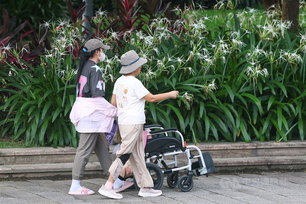 圖為台北市中山區一處公園內移工與雇主一同散步活動。（中央社檔案照片）
