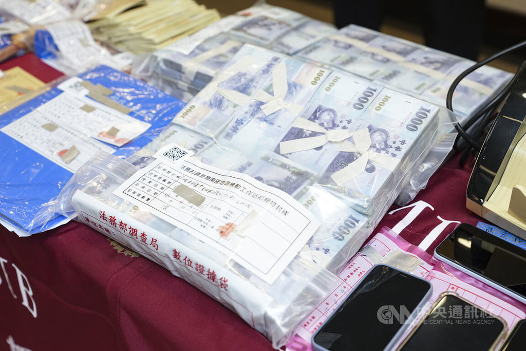 調查局8日在新北市新店區舉行「115年打擊不法金流專案」成果記者會，公布查緝地下通匯、水房洗錢等案件成果，並展示查扣現金、手機等證物。中央社記者鄭清元攝　115年9月8日
