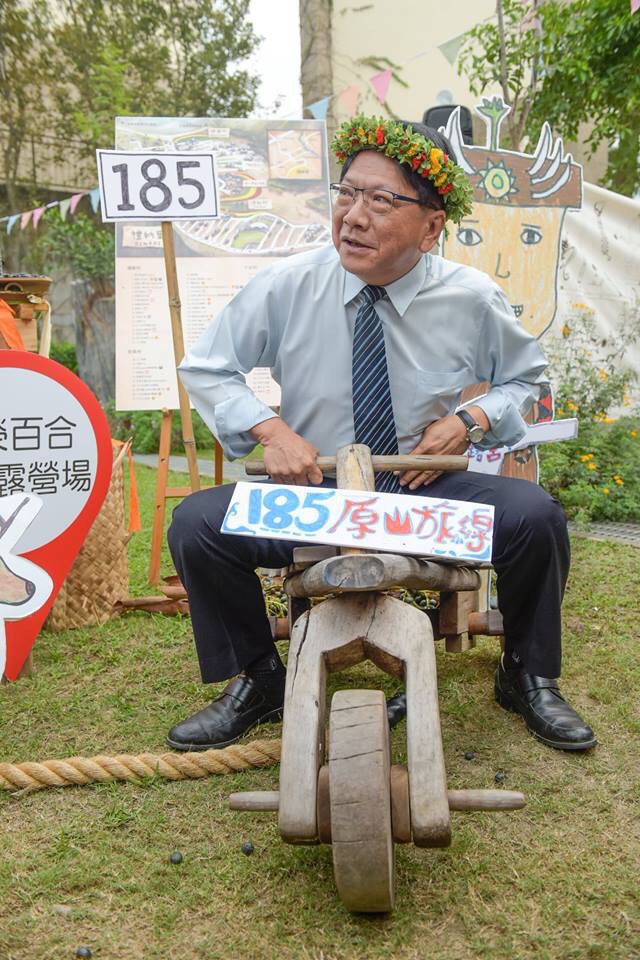 屏東縣政府將於12月16日、17日在原鄉部落的5所校園露營舉辦「聯合大露營」，屏東縣長潘孟安乘坐木製的小型腳踏車。 圖：屏東縣政府/提供