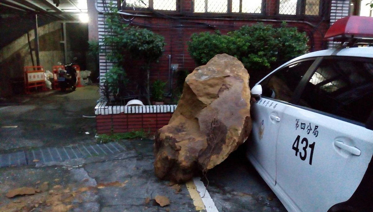 基隆市安樂區安一路安定派出所今日凌晨發生落石意外，砸中警車車門，駕駛員警逃過一劫。 圖：基隆市政府 / 提供
