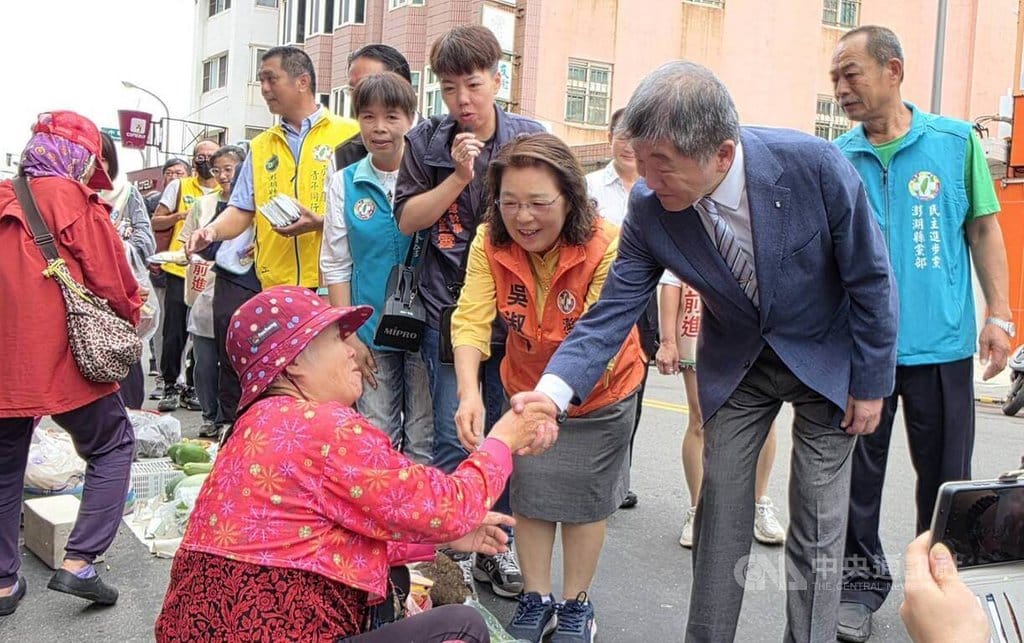 行政院政務委員陳時中（右1）13日陪同民進黨縣長參選人吳淑瑾（右2），前往澎湖北辰市場向攤商和民眾拜票，現場加油凍蒜聲不斷。 圖：中央社