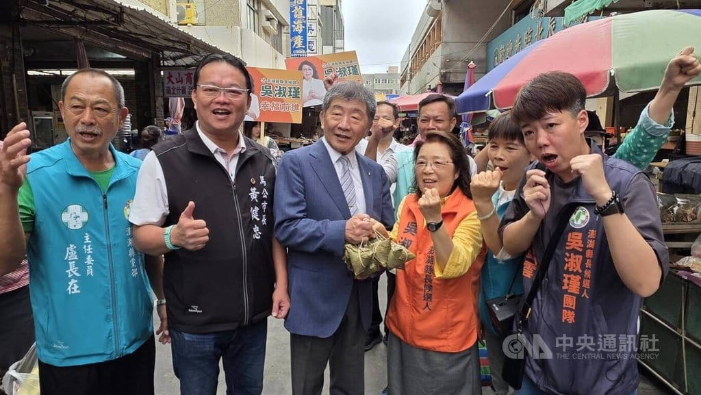 澎湖縣長選舉加溫，行政院政務委員陳時中（左3）13日陪同民進黨縣長參選人吳淑瑾（右2）等所有公職參選人，前往北辰市場向攤商和民眾拜票，同時致贈肉粽給吳淑瑾，現場加油凍蒜聲不斷。 圖：中央社
