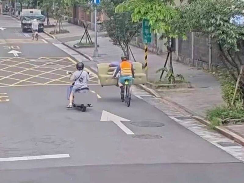 騎著腳踏車的男子，前方竟載運著3人座的沙發沿路行駛。 圖：翻攝畫面