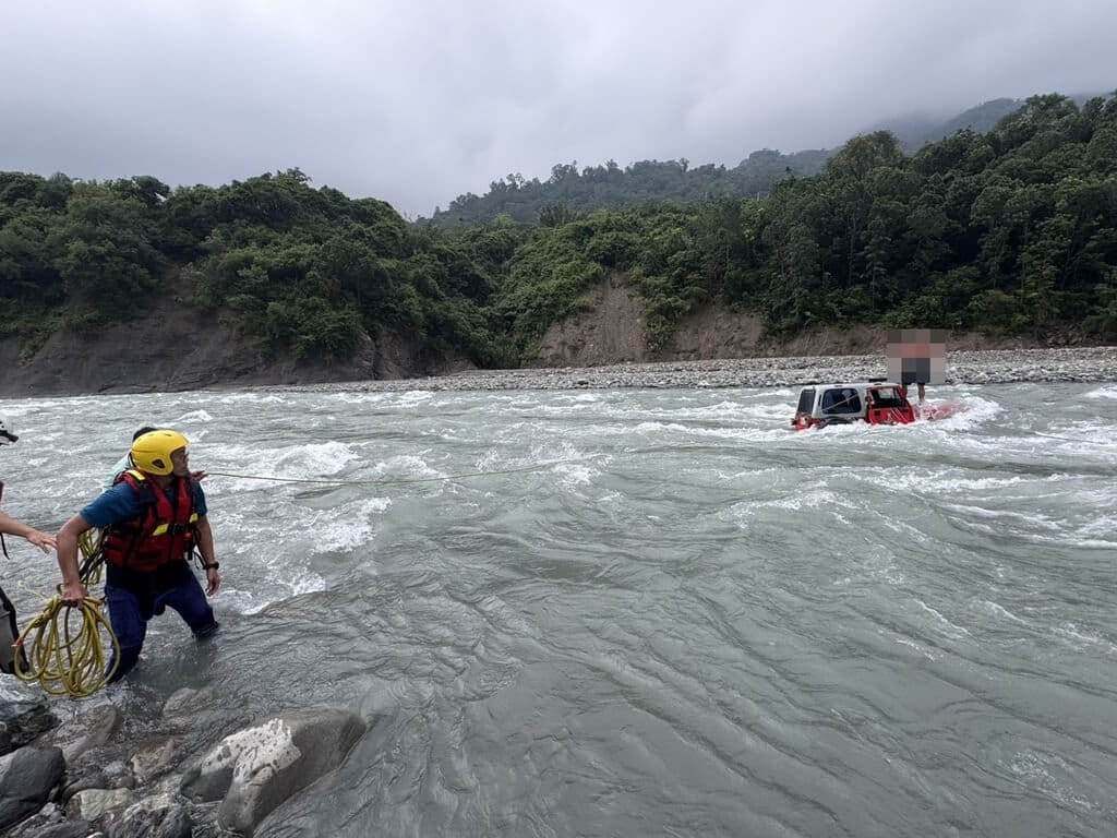 高雄市消防局16日獲報指桃源區索阿紀吊橋下方河床有人員受困，現場為2輛吉普車受困河床，其中1人自行游上岸，2人在車頂待救，消防人員到場以拋繩槍架設繩索協助脫困，所幸全員平安。（高雄市消防局提供）中央社記者張已亷傳真　115年9月16日