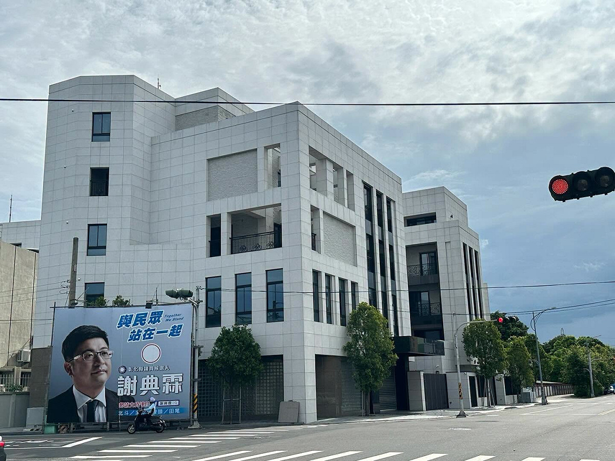 謝典霖在自家超級豪宅旁架設競選看板宣稱「與民眾站在一起」。 圖：取自吳音寧臉書