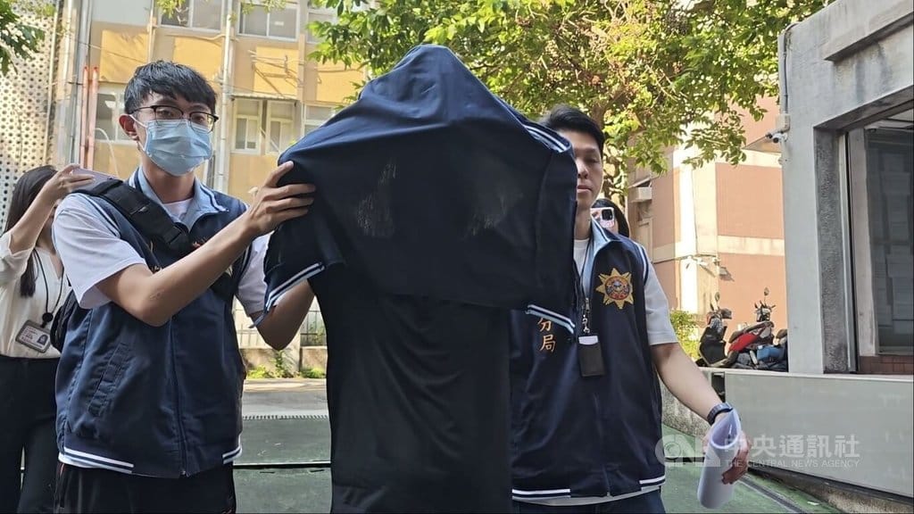 無黨籍立委高金素梅助理張俊傑棄保潛逃案，涉提供車輛協助逃亡的伍姓男子（外套遮頭者）17日由警方移送台北地檢署複訊，檢方訊後諭令新台幣20萬元交保。中央社記者劉世怡攝　115年9月17日