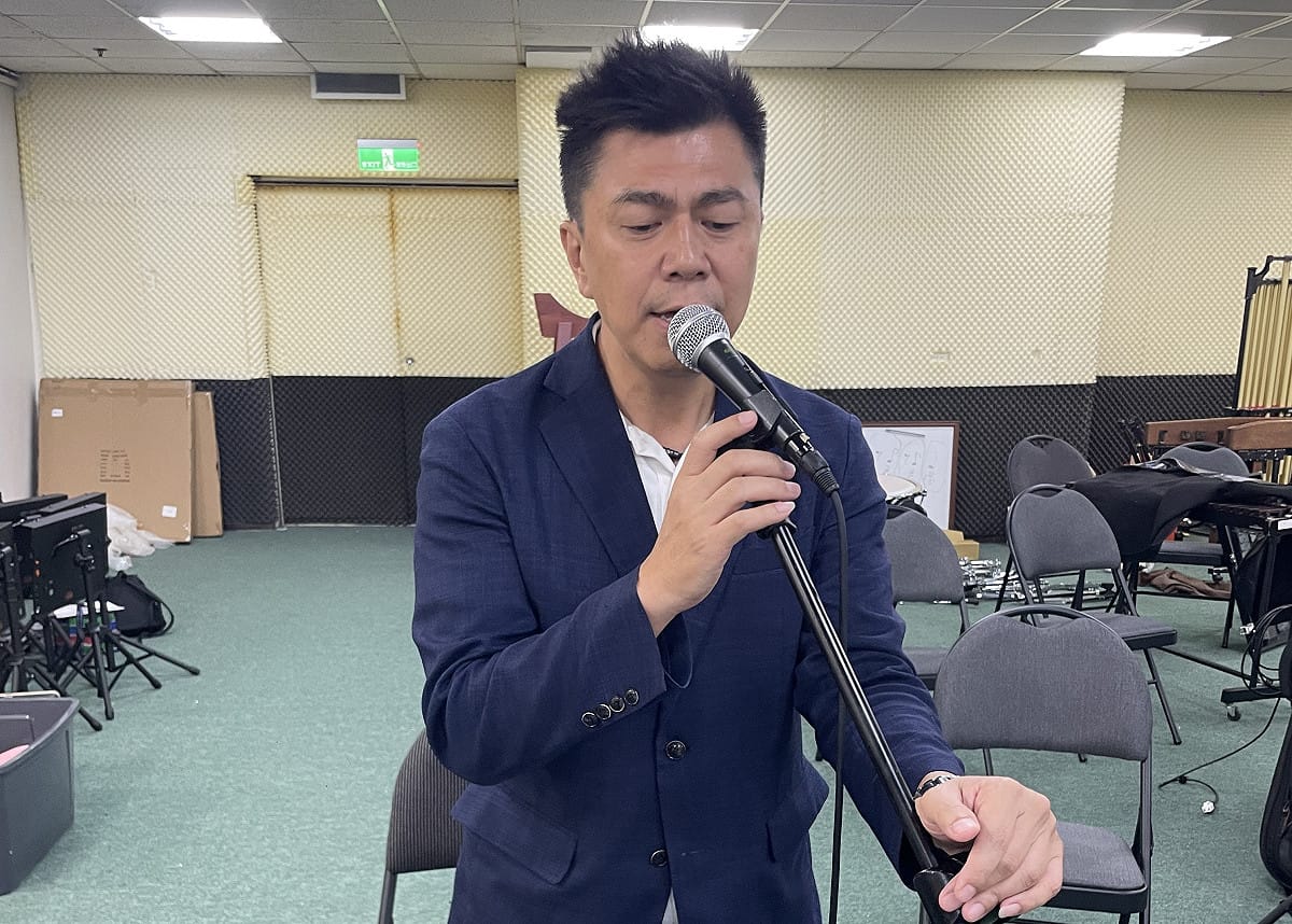 黃文志抽空練唱，準備在廟埕音樂會上高歌。 圖：黃文志競辦／提供