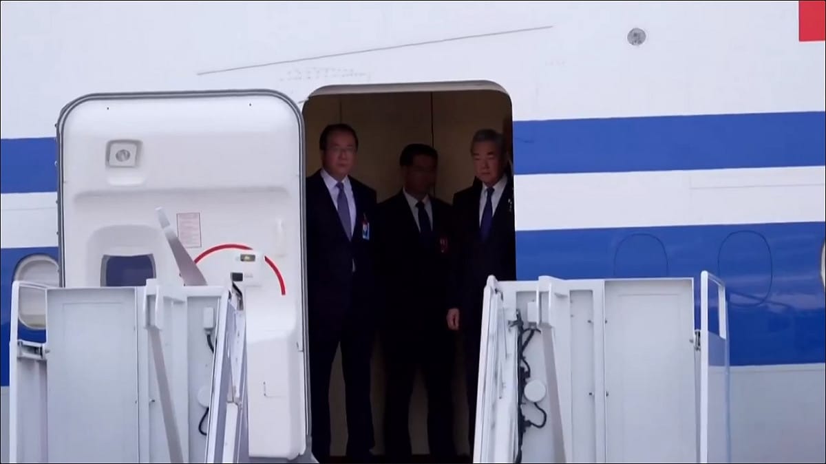 在習近平下機前，美方接待人員忙碌的在地面鋪紅毯，包含外交部長王毅在內的中國官員則在機艙門附近持續觀望。 圖：擷取自 @whyyoutouzhele X 分享影片