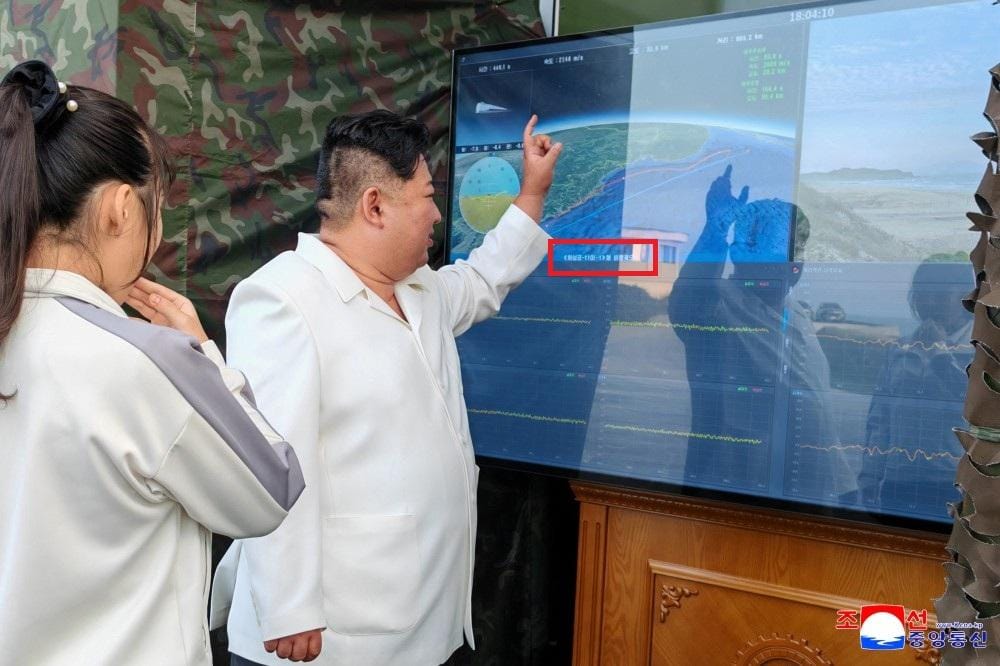 金正恩與女兒金主愛觀看螢幕，畫面標示「火星炮-11戊-1型飛行軌道」。 圖：翻攝朝中社