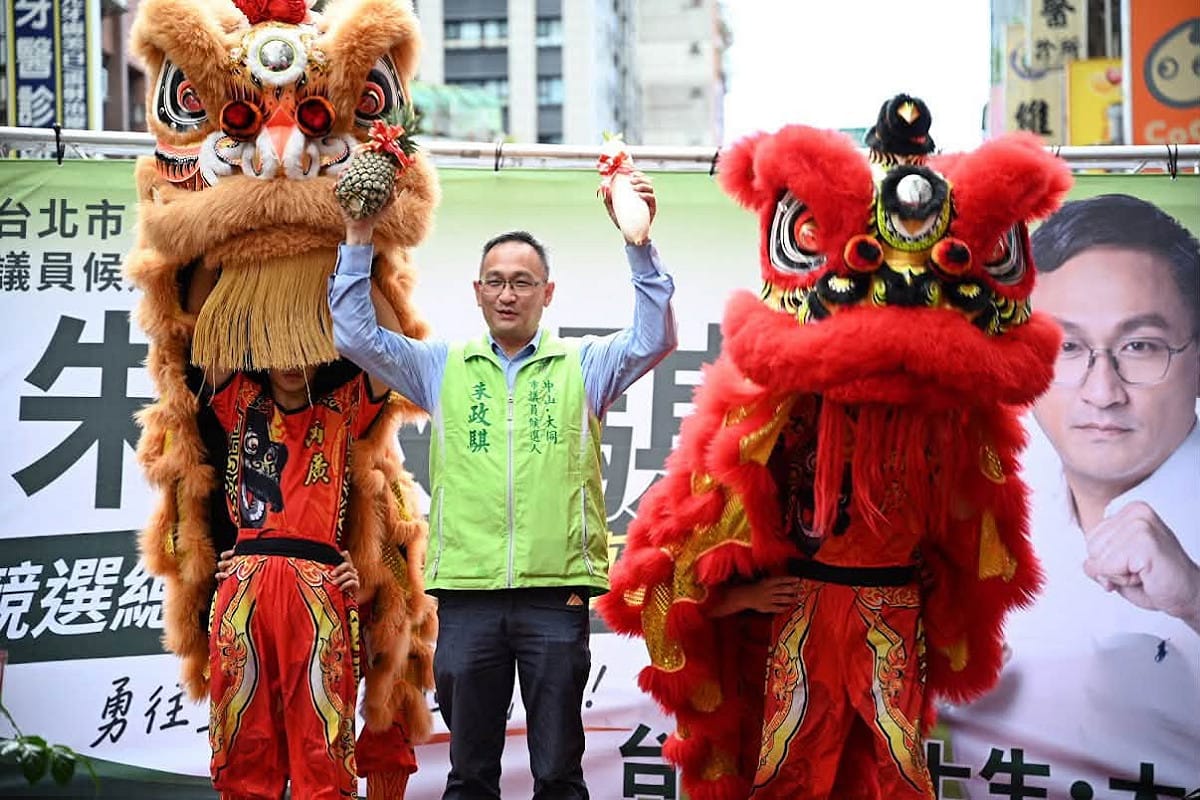 因涉共諜案遭民進黨除名的朱政騏，以無黨籍身份登記參選北市中山大同區議員，遭檢舉文宣品使用民進黨黨徽。圖為競選總部成立，朱穿著色系相近競選背心登台。 圖：翻攝「臉書」朱政騏