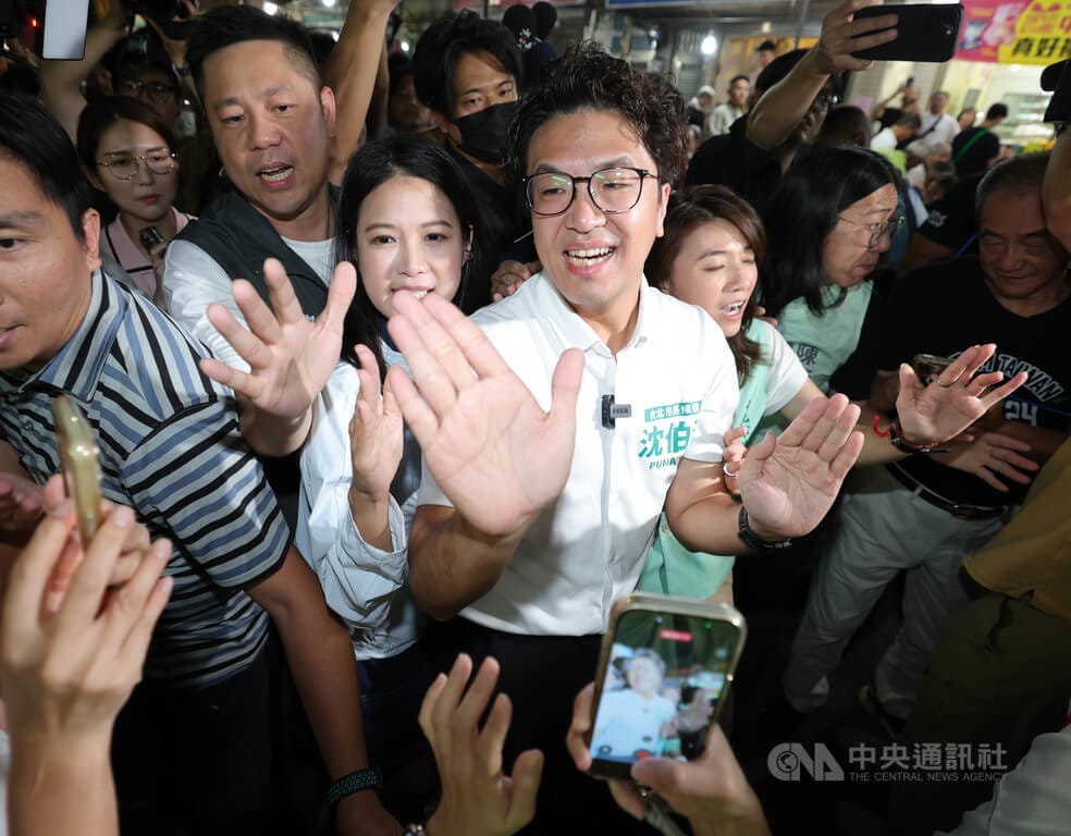 民進黨台北市長參選人沈伯洋（前中）26日晚間出席「台北市中庄仔福德宮福德正神聖誕千秋晚宴」，進場時和民眾擊掌致意，互動熱絡。 圖:中央社提供