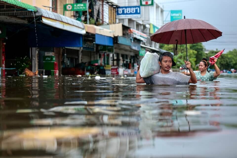 泰國受豪雨影響，曼谷及25個府傳淹水災情。圖為27日曼谷民眾涉水走在街頭。 （路透社）