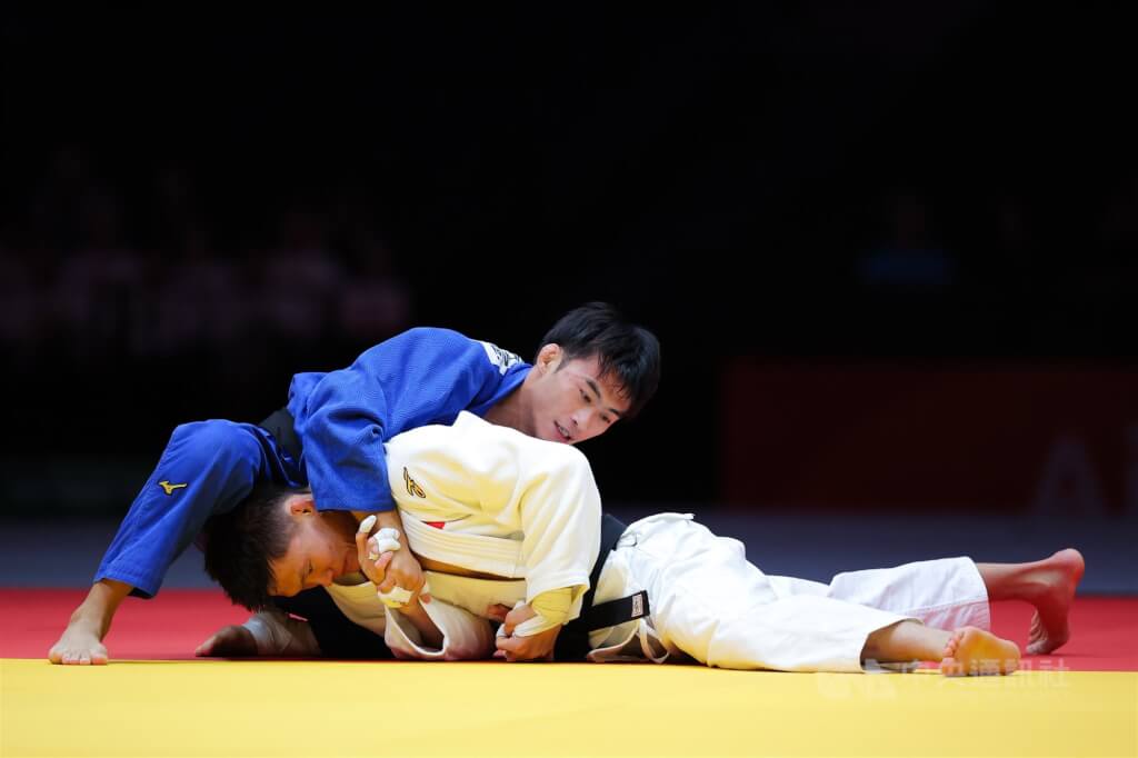 名古屋亞運30日柔道男子60公斤級銅牌戰，台灣柔道一哥楊勇緯（藍衣）多次使用招牌地板動作仍無法得分，最終在黃金得分制搶攻失手惜敗。中央社記者翁睿坤愛知攝　115年9月30日