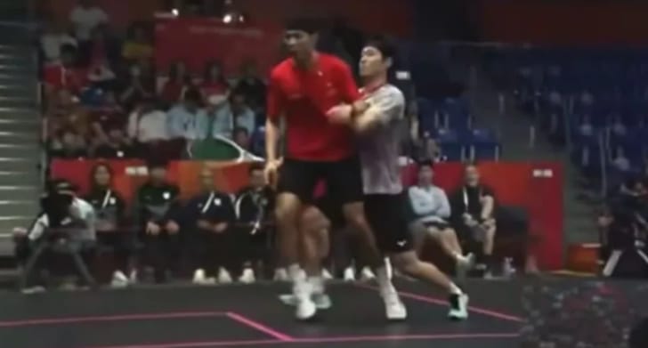 日本選手遠藤共峻(右)在亞運壁球比賽中，因快速移動走位，與香港選手梁子軒發生多次衝撞。 圖 : 影片截圖