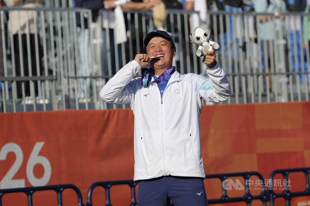 台灣好手張正韋1日在名古屋亞運射箭男子複合弓個人賽摘下銀牌，賽後張正韋開心咬獎牌慶祝。中央社記者翁睿坤愛知攝　115年10月1日