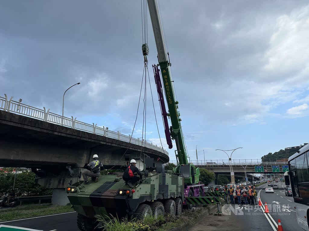 一輛國軍雲豹甲車2日清晨行經新北淡水關渡大橋匝道時自撞分隔島，造成燈桿斷裂，一度影響交通，軍方委託吊車將雲豹甲車拖離事故現場。（翻攝照片）中央社記者曹亞沿傳真　115年10月2日
