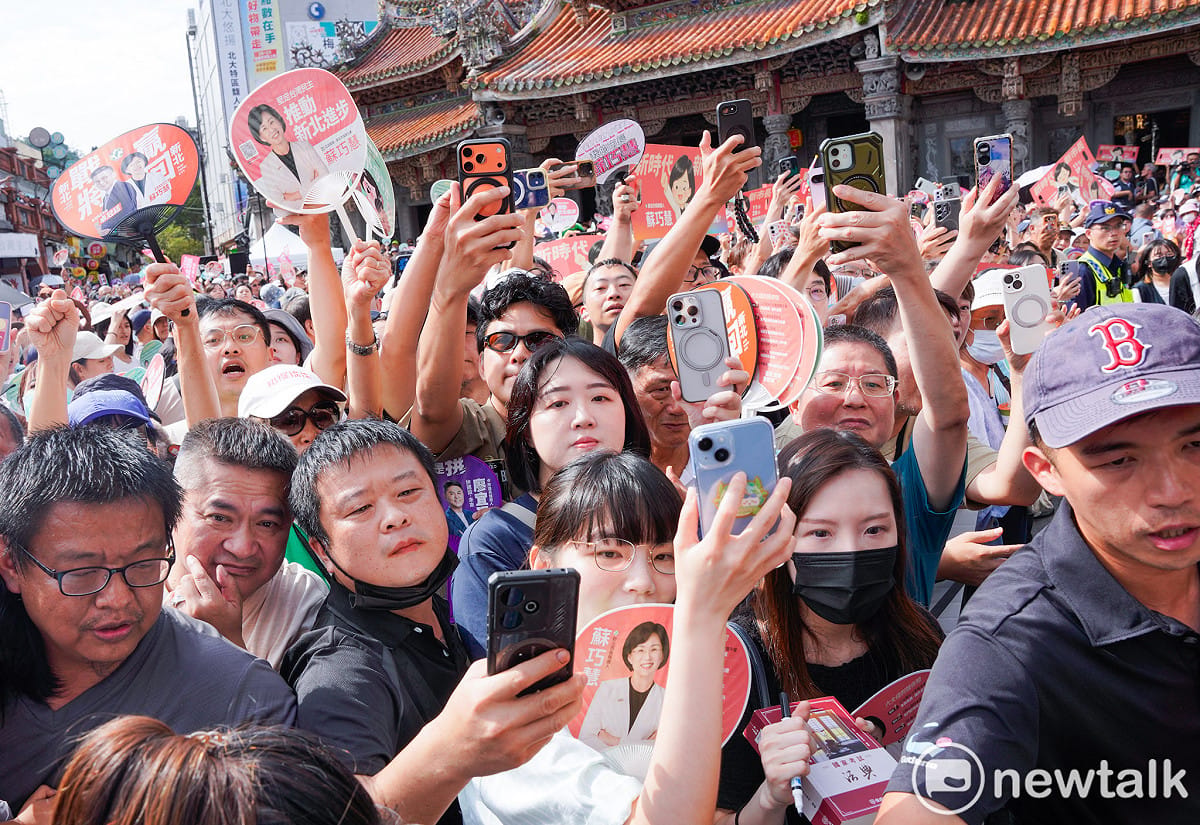 蘇巧慧和沈伯洋抵達三峽祖師廟時，民眾高舉手機拍攝或向兩人揮手加油打氣。 圖：張良一/攝