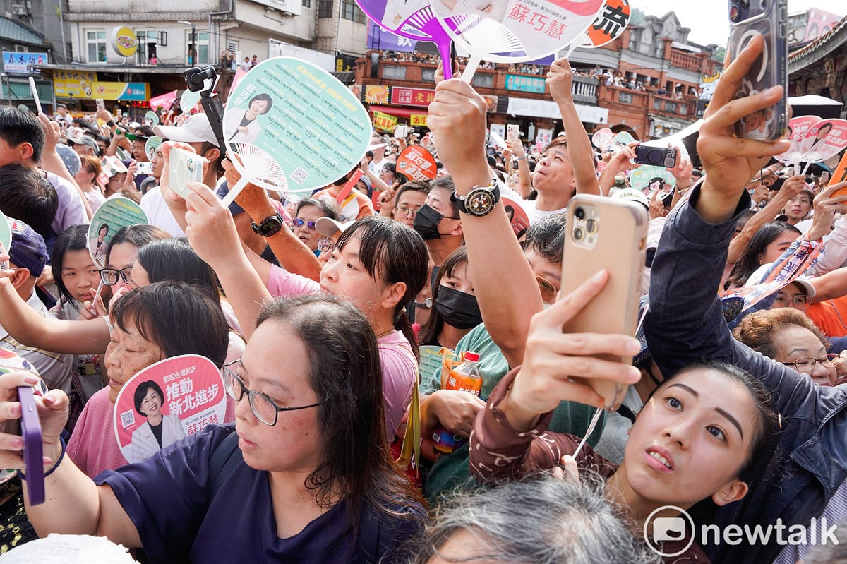 蘇巧慧和沈伯洋抵達三峽祖師廟時，民眾高舉手機拍攝或向兩人揮手加油打氣。 圖：張良一/攝