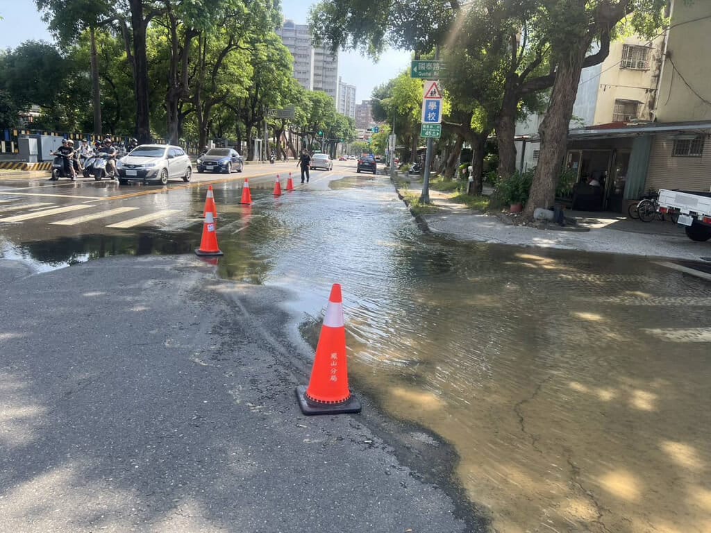 高雄市鳳山區國泰路二段、新富路4日疑似地下水管破裂，造成路面淹水，警方派員至現場交管。 圖：高雄市政府警察局鳳山分局提供