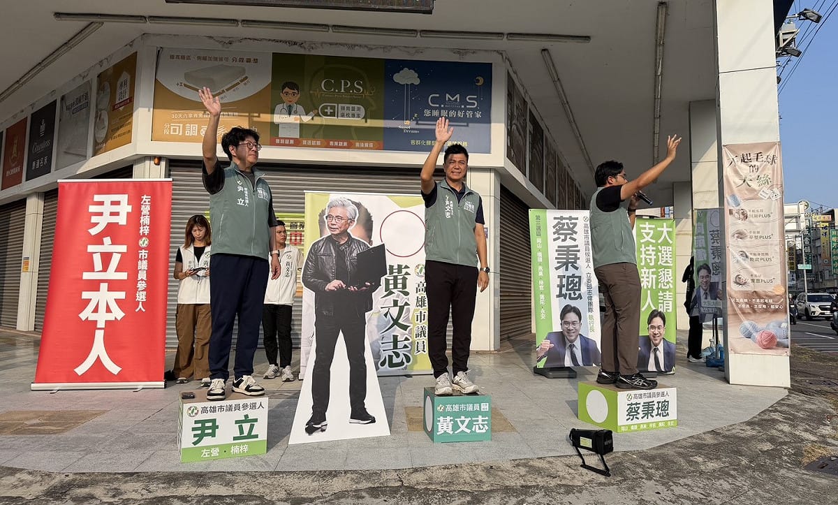 尹立、黃文志、蔡秉璁(左至右)與「黃隆勳」人形立牌站路口拜票。 圖：尹立競總／提供