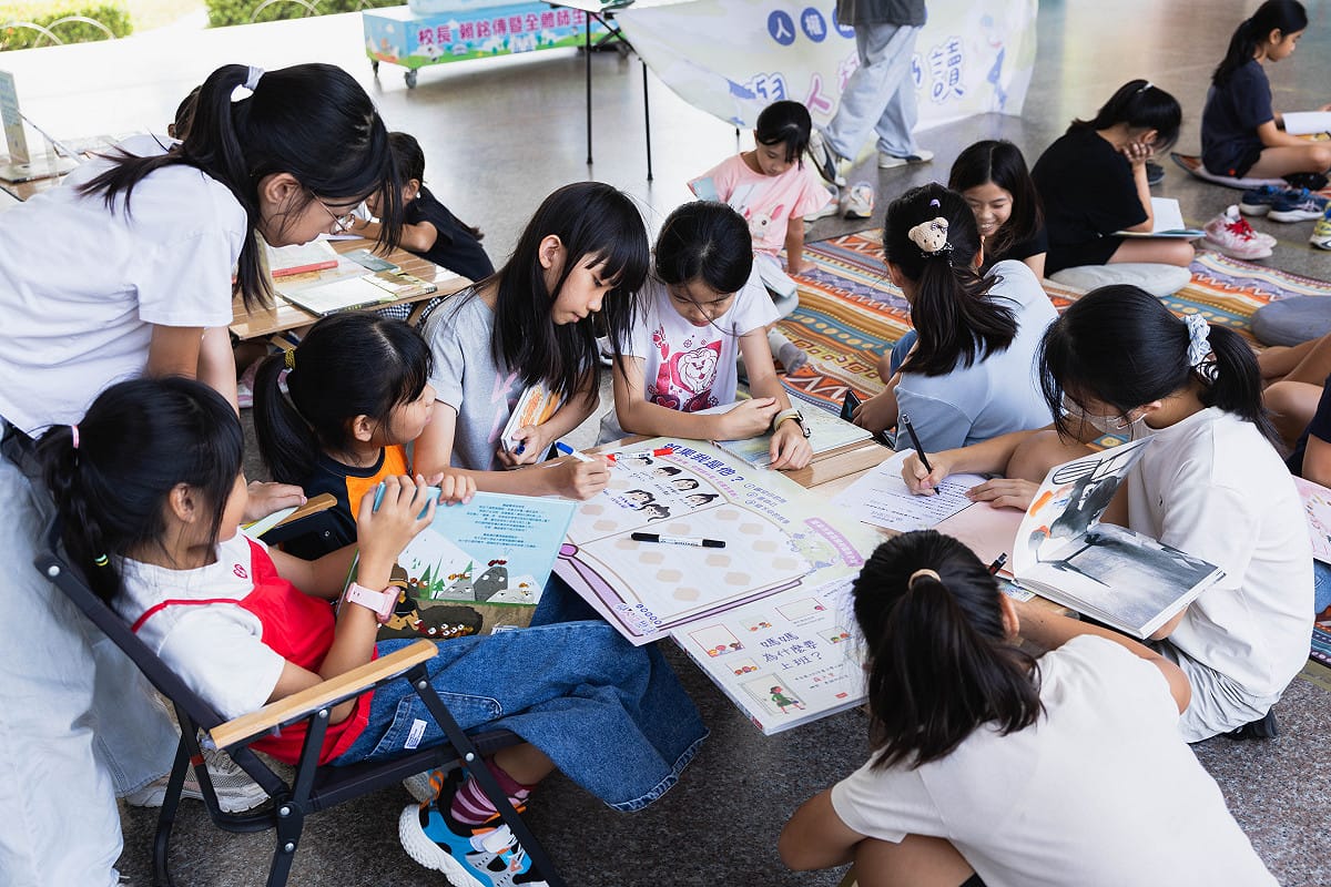 台南勝利國小學生聚集在桌前，閱讀同學留下的心得。 圖：國家人權博物館提供