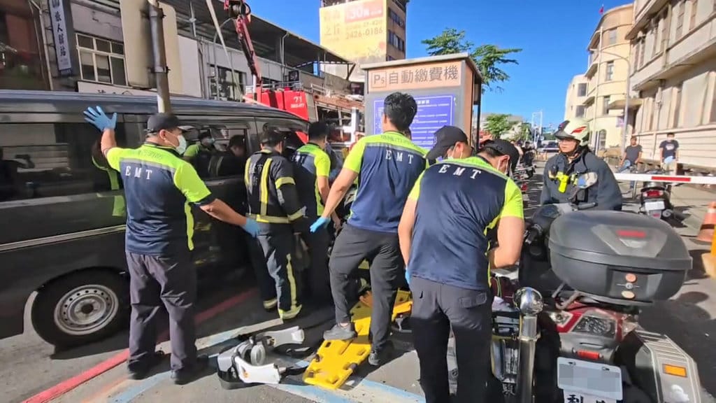 潘姓女子19日下午騎乘機車行經基隆市港西街時，疑失控撞上對向廂型車後飛起，受困廂型車底，消防人員利用器材車吊臂，將廂型車車體抬升將人拉出，潘女經送醫急救後仍宣告不治。（讀者提供）中央社記者王朝鈺傳真　115年10月19日