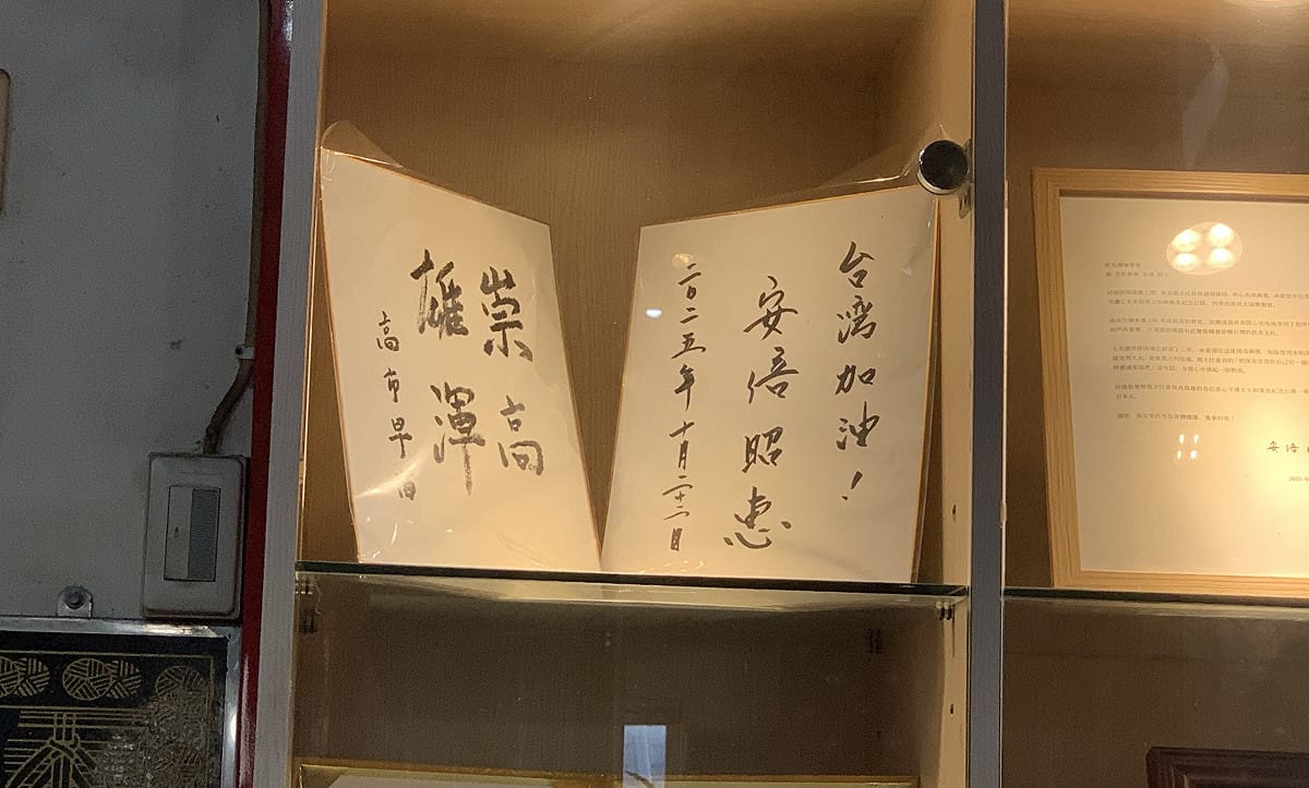 紅毛港保安堂櫥窗保存高市早苗當選首相前，於2025 年 4 月 29 日來訪時所親簽的「崇高雄渾」墨寶。 圖：孫家銘／拍攝
