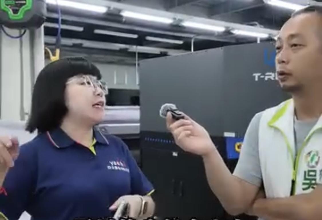 吳昱鋒(右)親訪洋流飄帶台灣印刷工廠，以實際影像證明不是「中國淘寶貨」。 圖：截自吳昱鋒影片